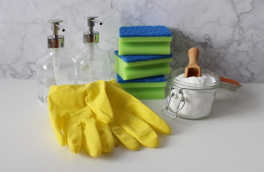 洗剤ボトル、スポンジ、粉石けんが入った瓶、黄色いゴム手袋