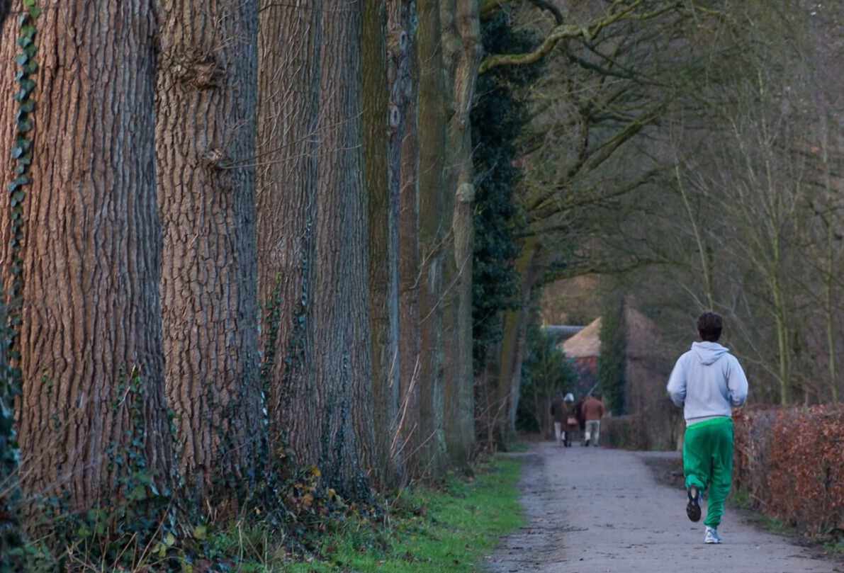 街路樹と走る男性